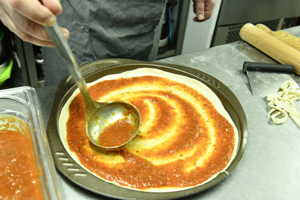 Étaler de manière circulaire la sauce tomate