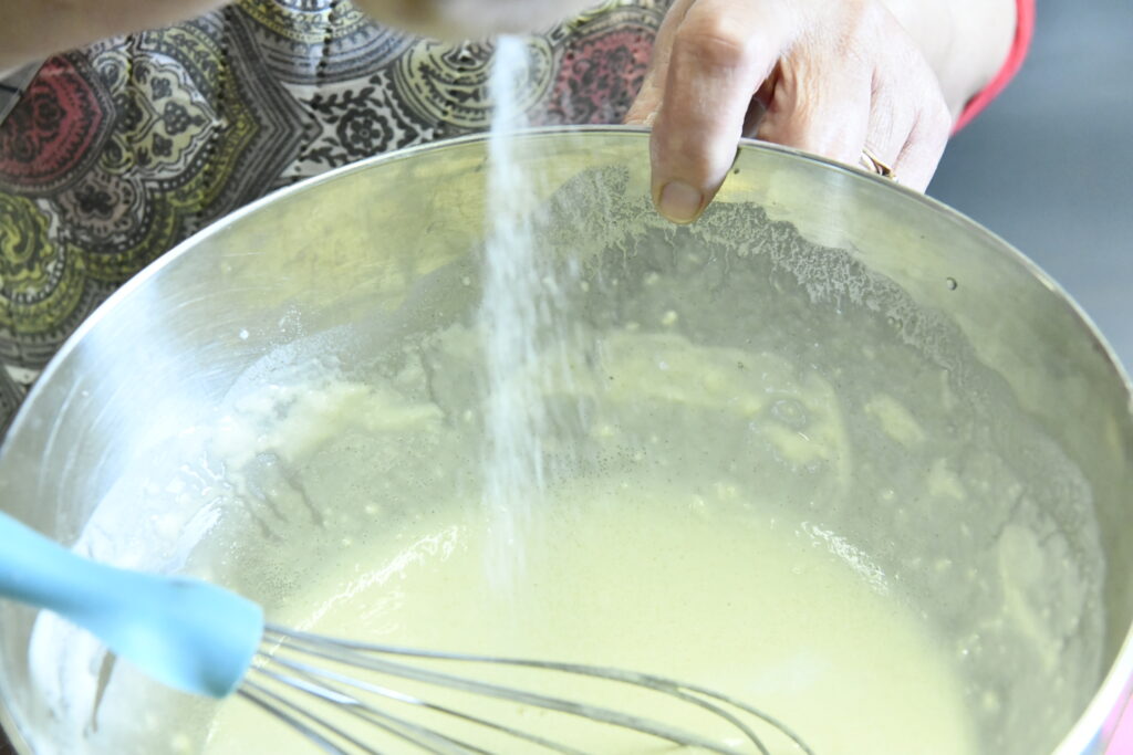 Intégration du sel dans le mélange de beignet de poireaux à la mode corse.