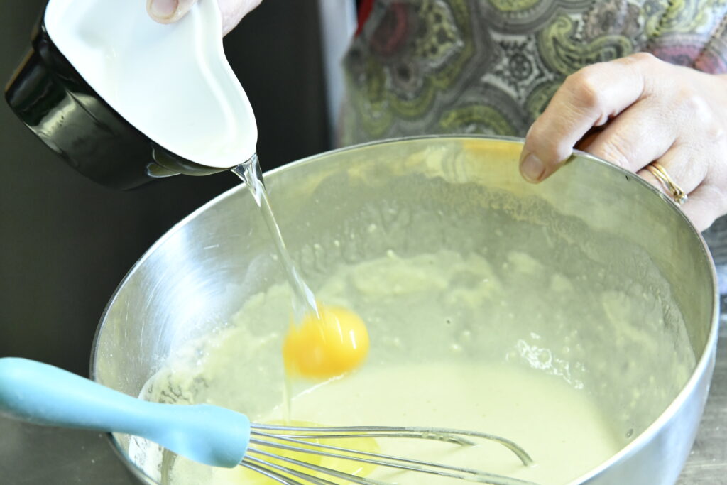 Incorporation de deux oeufs dans le mélange de beignet poireaux