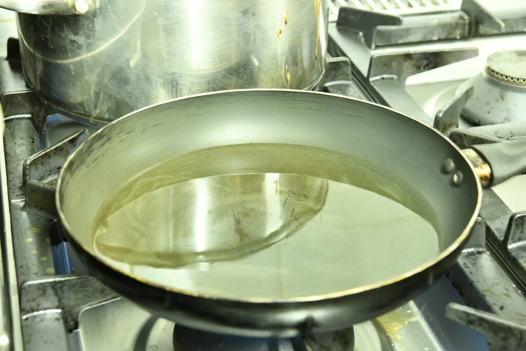 une fond d'huile de tournesol dans une poêle en chauffe pour accueillir le les beignets de poireaux corses