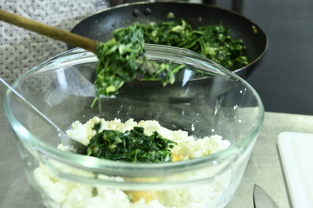 Ajout du mélange épinards, oignons  dans le brocciu pour la recette corse des sturzapretti