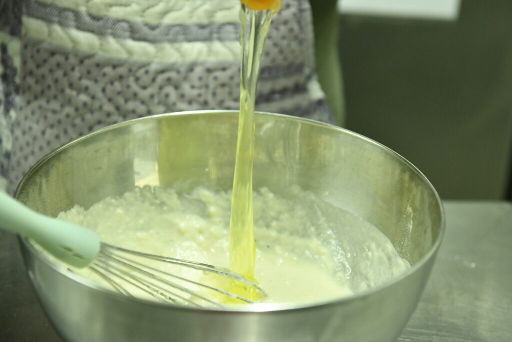 Incorporation-des-oeufs-dans-la-préparation-des-beignets-de-fromage-corse